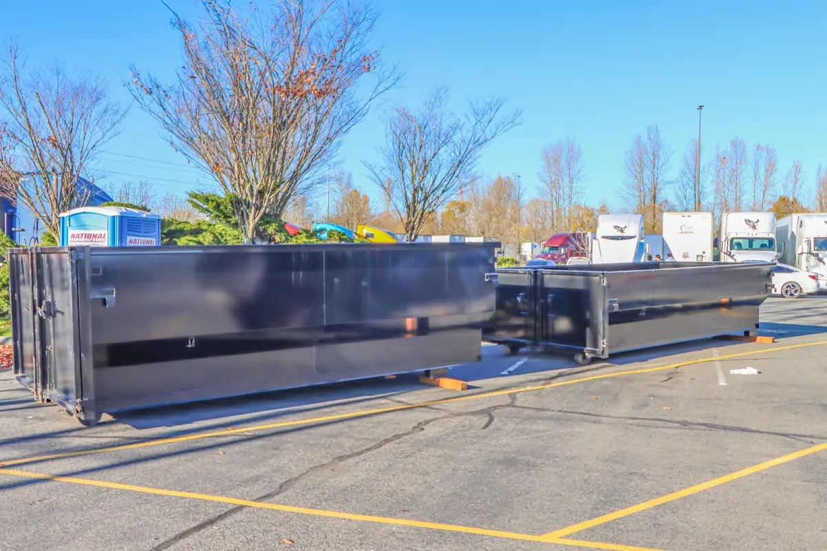 Professional dumpster rental service with roll-off container on residential driveway in Pemberton